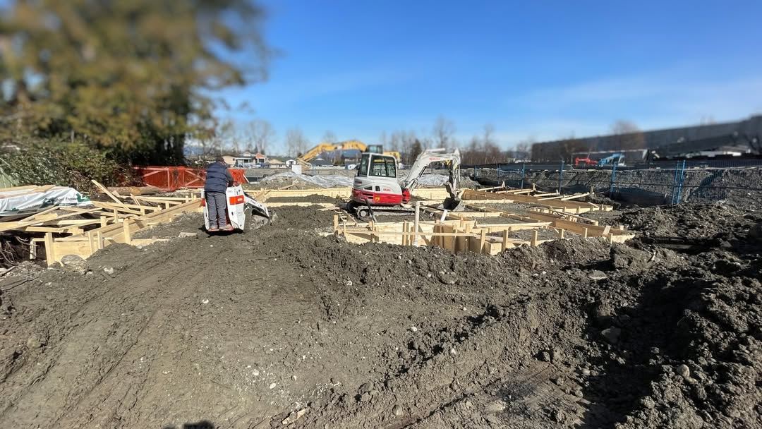 Excavator and skid steer working a foundation backfill