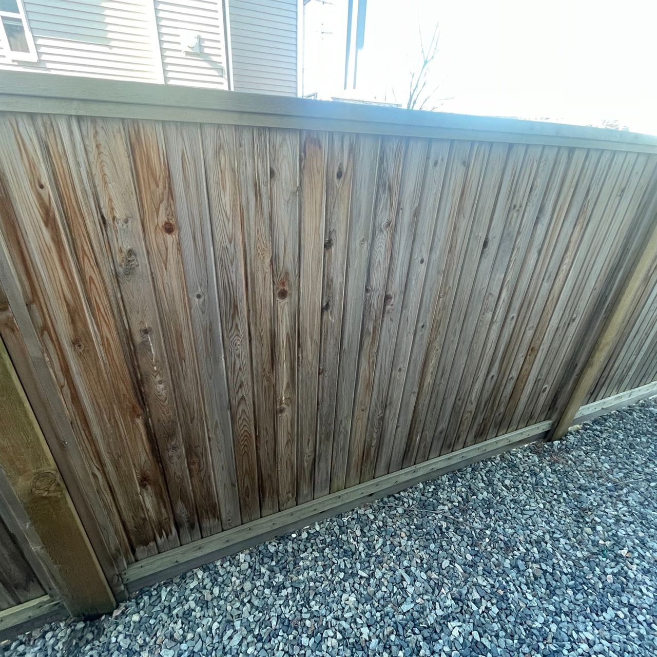 Finished vertical cedar privacy fence with gravel border
