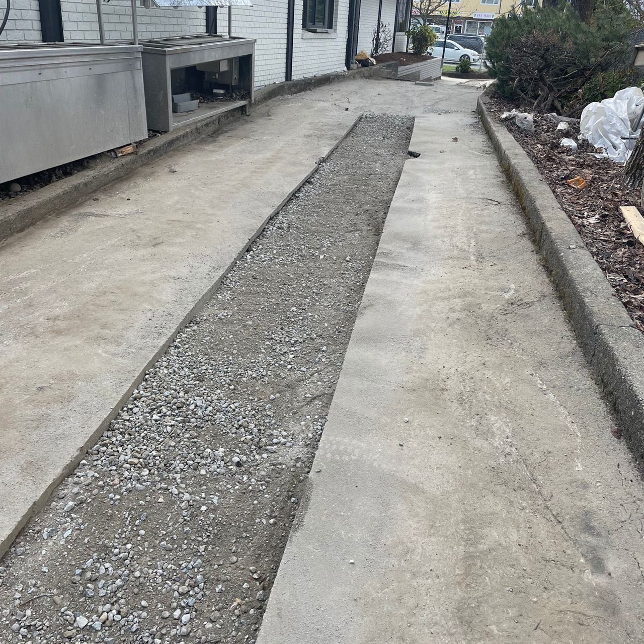 Asphalt paving prep — gravel base and trenches ready for surface pour