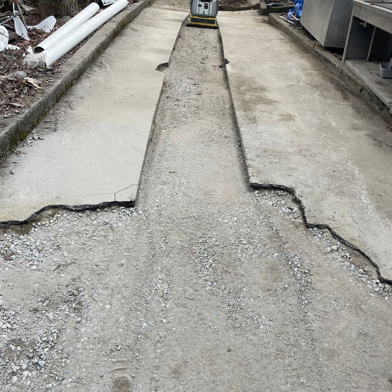 Asphalt paving prep — driveway surface cut and opened for utility work