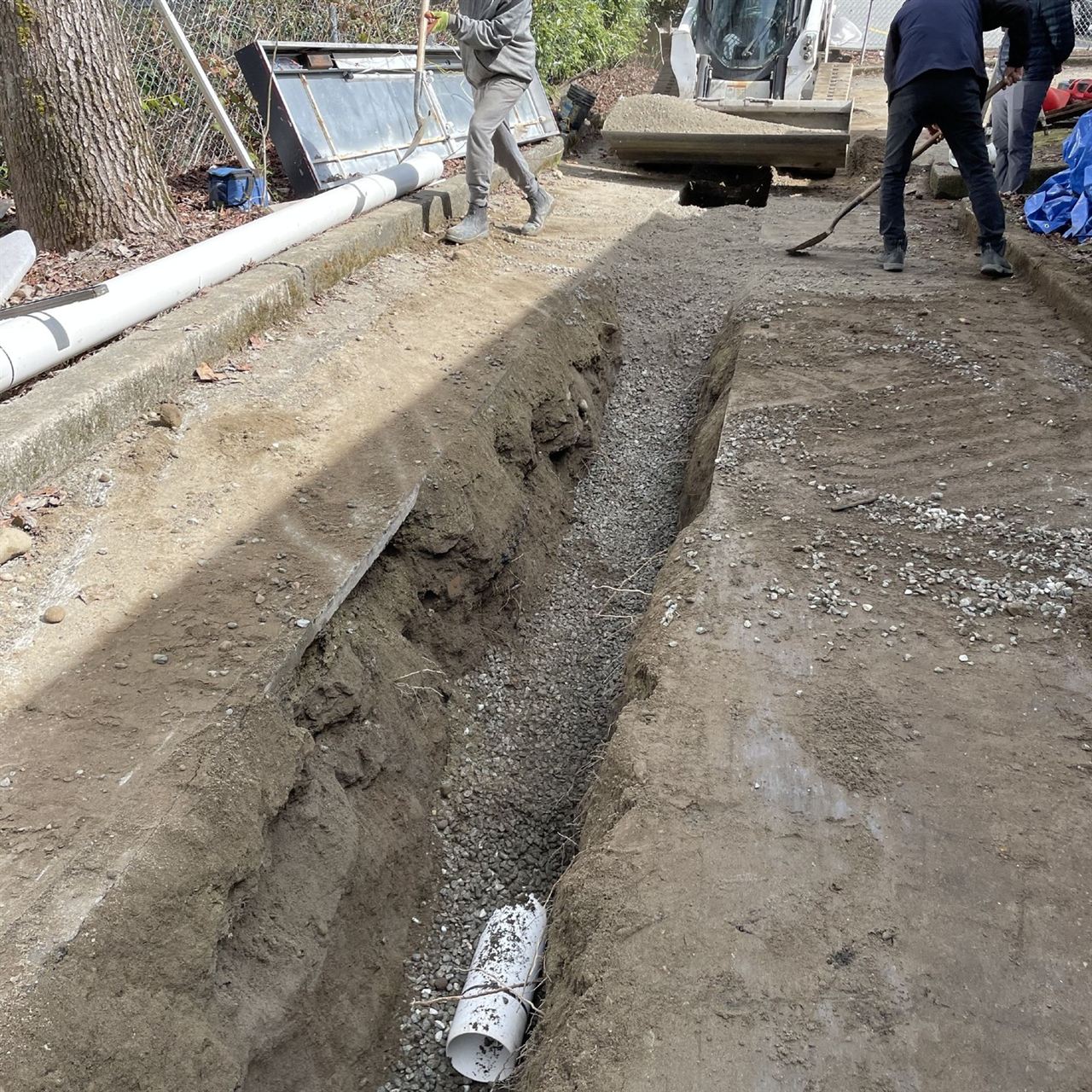 Crew installing services in an open utility trench