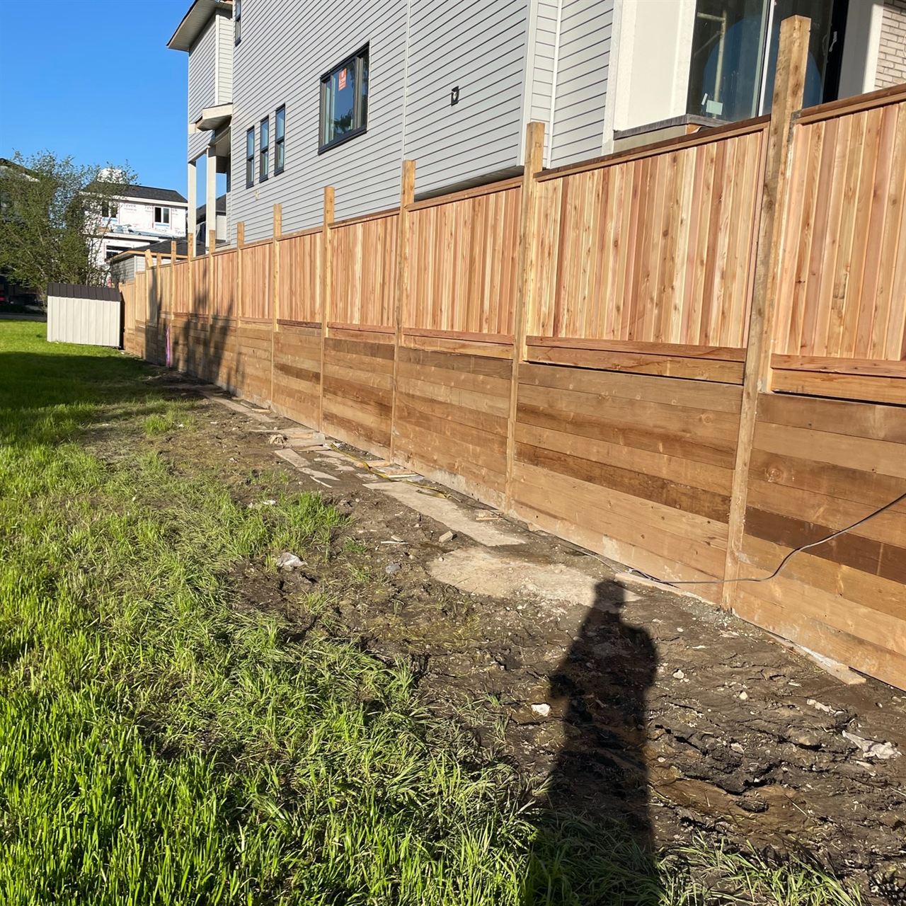 Cedar fence under construction with horizontal base boards