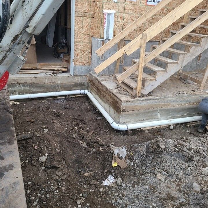 Perimeter drain pipe at a concrete entry stair